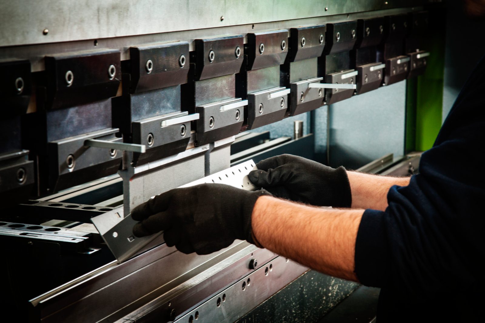 Person operating industrial metal bending machine.